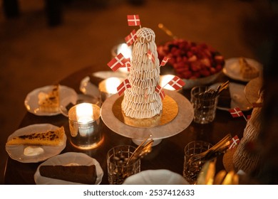 A beautifully arranged dessert table featuring pastries, danish cheeses, cakes, and a large floral centerpiece with red roses and hydrangeas. Soft candlelight creates a warm, inviting ambiance - Powered by Shutterstock