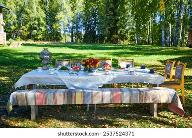 A beautifully arranged table ready for outdoor dining with vibrant flowers and rustic chairs. - Powered by Shutterstock