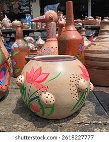 A beautifully composed interior image featuring traditional Bangladeshi clay pots (matir pati) tastefully placed in a modern drawing room. The fusion of rustic earthenware with minimalistic decor