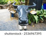 A beautifully crafted black buffalo statue stands proudly in a vibrant local market in Thailand, symbolizing the rich agricultural heritage and cultural significance of this iconic animal.