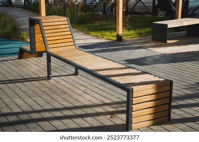 A beautifully crafted wooden bench with a sturdy metal frame on a polished deck creates an inviting outdoor seating area, perfect for relaxing and enjoying the fresh air and nature - Powered by Shutterstock