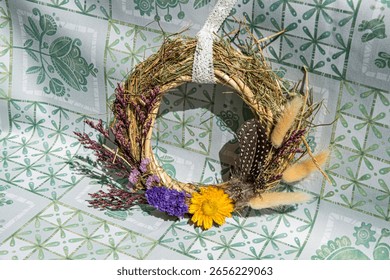 Beautifully crafted wreath features an array of dried flowers and herbs. Ideal decoration for welcoming seasons, creating inviting atmospheres in homes or during gatherings.