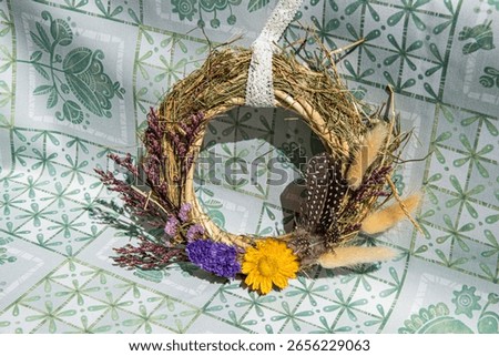 Beautifully crafted wreath features an array of dried flowers and herbs. Ideal decoration for welcoming seasons, creating inviting atmospheres in homes or during gatherings.