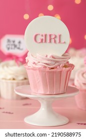 Beautifully Decorated Baby Shower Cupcake For Girl With Cream And Topper On Pink Wooden Table