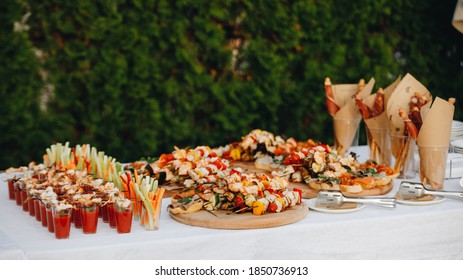 Beautifully Decorated Catering Banquet Table With Different Food Snacks And Appetizers With Sandwich, Caviar, Fresh Fruits On Corporate Christmas Birthday Party Event Or Wedding Celebration.