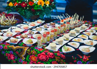 Beautifully Decorated Catering Banquet Table With Different Food Snacks And Appetizers With Sandwich, Caviar, Fresh Fruits On Corporate Party Event Or Wedding Celebration