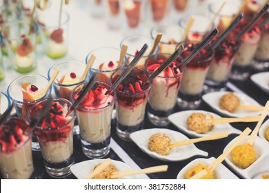 Beautifully decorated catering banquet table with different food snacks and appetizers with sandwich, caviar, fresh fruits on corporate christmas birthday party event or wedding celebration - Shutterstock ID 381752884