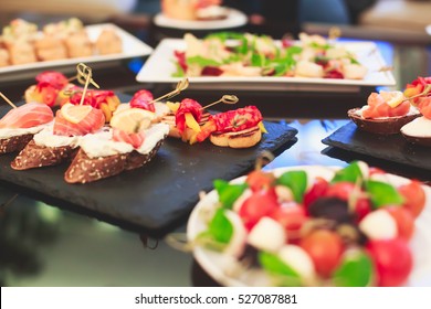 Beautifully Decorated Catering Banquet Table With Different Food Snacks And Appetizers On Corporate Christmas Birthday Party Event Or Wedding Celebration
