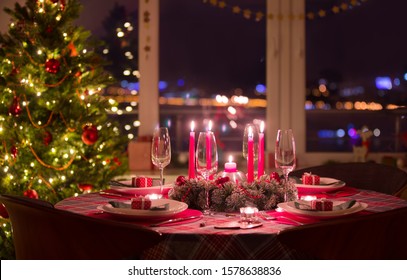 beautifully decorated Christmas table with candles and glasses near the Christmas tree - Powered by Shutterstock