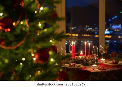 beautifully decorated Christmas table with candles and glasses near the Christmas tree - Powered by Shutterstock