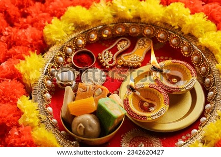 Beautifully Decorated Pooja Thali for festival celebration to worship rice grain and kumkum flowers hindu puja thali. Pooja Material Puja Sahitya in Hindu Religion from India arranged in a group.