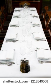 Beautifully decorated table with empty white plates, glasses and cutlery  on luxurious tablecloths