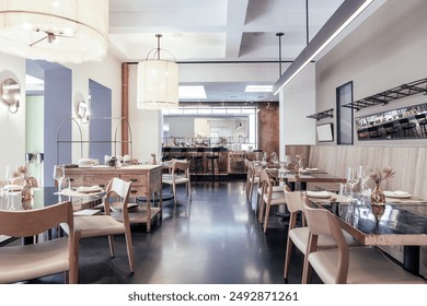 A beautifully designed restaurant interior showcasing a modern and elegant dining area. The space features contemporary furniture, including wooden chairs and tables set with glassware, plates. - Powered by Shutterstock