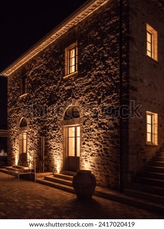 A beautifully illuminated stone edifice with outdoor seating, perfect for a cozy evening ambiance