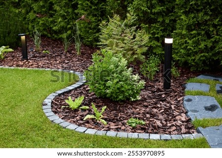 A Beautifully Landscaped Garden That Features Attractive Lights and Decorative Stones