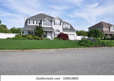 Beautifully Landscaped Two Story Suburban Home with blooming purple iris flowers curbside