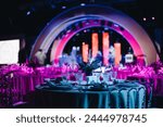 Beautifully organized event - round served table banquet ready for guests, round decorated table with empty plate, glasses, forks, napkin. Elegant dinner table 