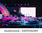 Beautifully organized event - round served table banquet ready for guests, round decorated table with empty plate, glasses, forks, napkin. Elegant dinner table 