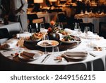 Beautifully organized event - round served table banquet ready for guests, round decorated table with empty plate, glasses, forks, napkin. Elegant dinner table 