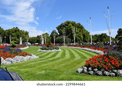 The beautifully pristine gardens surrounding Buckingham Palace with vibrant green grass and stunning flowers of all different colors