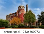 the beautifully restored tower house of the former Vulkan lighting factory from 1909 in Cologne Ehrenfeld with autumnal colors of the tasteful plantings