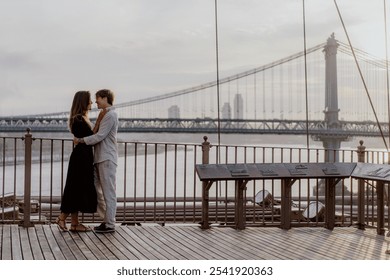 A beautifully romantic moment was captured between an affectionate couple, framed by a stunning bridge backdrop. Manhattan and Brooklyn bridge in New York. - Powered by Shutterstock