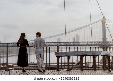 A beautifully romantic moment was captured between an affectionate couple, framed by a stunning bridge backdrop. Manhattan and Brooklyn bridge in New York. - Powered by Shutterstock