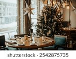 A beautifully set dining table in a cozy restaurant, adorned with holiday decorations, a sparkling Christmas tree, and star ornaments. Snowy window view creates a warm festive ambiance