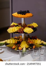 Beautifully Sliced ​​fruit Spread Out On A Tray On A Background Of Glasses