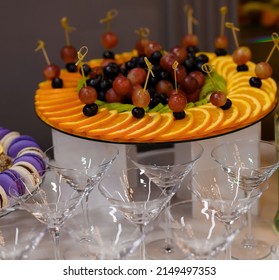 Beautifully Sliced ​​fruit Spread Out On A Tray On A Background Of Glasses