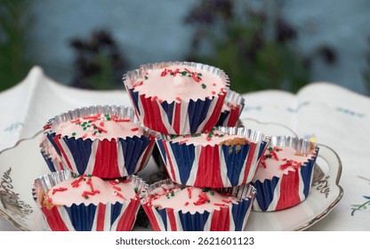 A beautifully staged VE Day 80th Anniversary celebration capturing the essence of British heritage and royal tradition. Set in a picturesque garden or village green, the vintage afternoon tea party 