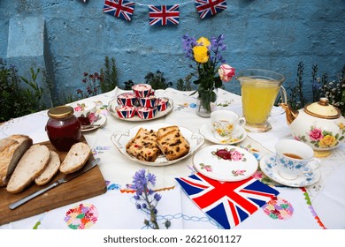 A beautifully staged VE Day 80th Anniversary celebration capturing the essence of British heritage and royal tradition. Set in a picturesque garden or village green, the vintage afternoon tea party  - Powered by Shutterstock - Get 15% off with code: PIKWIZARD15