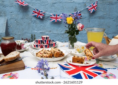 A beautifully staged VE Day 80th Anniversary celebration capturing the essence of British heritage and royal tradition. Set in a picturesque garden or village green, the vintage afternoon tea party 