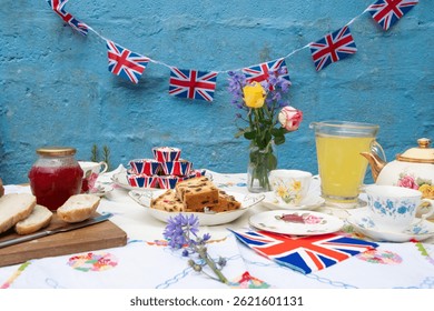 A beautifully staged VE Day 80th Anniversary celebration capturing the essence of British heritage and royal tradition. Set in a picturesque garden or village green, the vintage afternoon tea party 