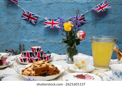 A beautifully staged VE Day 80th Anniversary celebration capturing the essence of British heritage and royal tradition. Set in a picturesque garden or village green, the vintage afternoon tea party 