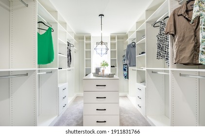 Beautifully Staged Walk In Closet With Custom White Cabinets