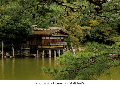 A beautifully tranquil lakeside pavilion is nestled tightly among the lush greenery and serene waters nearby - Powered by Shutterstock