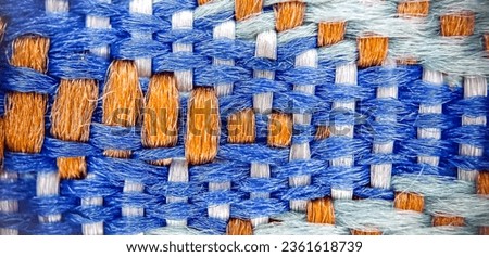 A beautifully woven cotton yarn pattern featuring Flickr blue, orange peel, light cyan, and white, showcasing precise and interconnected stitches