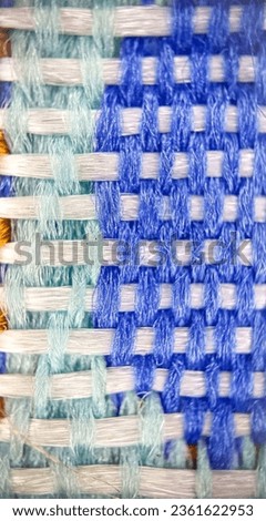A beautifully woven cotton yarn pattern featuring Flickr blue, light cyan, and white, showcasing precise and interconnected stitches.