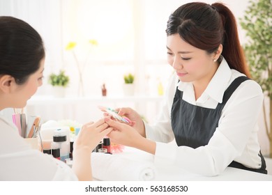 Beauty Asian Chinese Manicurist Showing Color Shellac Nail Polish For Her Customer To Selects Manicure Letter Of Nail Services In Beauty Salon.