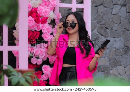 Beauty of Asian girl in pink shirt holding glasses, cheerful candid, carrying cellphone, flower decoration for fashion, lifestyle, banner, promo content