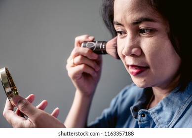 Beauty asian woman applying makeup with brush on. Beautiful asian woman face and Perfect skin. 