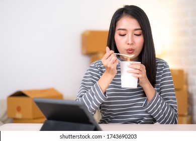 Beauty Asian Woman Eating Noodle Cup And Working In Office