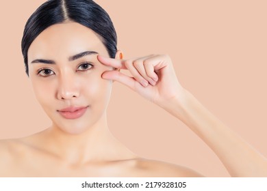 Beauty asian woman picking corner of her eye Beautiful girl get anti age treatment for wrinkles and crow's feet at corner of the eye Attractive young woman showing that she does not have crow's feet