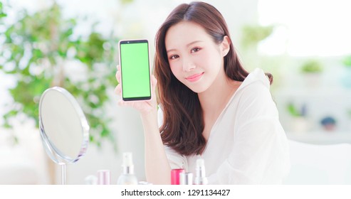 Beauty Asian Woman Show Smart Phone With Skin Care Products At Home