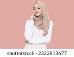 Beauty Asian young muslim girl wear hijab headscarf smiling and thinking isolated on pink background.
