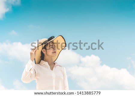 Beauty Attractive Asian woman wearing white shirt and hat relax looking up to the blue sky smile and happiness in summer vacations,Summer holiday concept