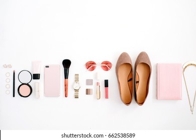 Beauty blog fashion concept. Female pink styled accessories: cell phone, watches, sunglasses, notebook, cosmetics, shoes on white background. Flat lay, top view trendy feminine background.