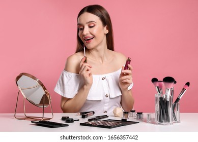 Beauty Blogger Applying Lipgloss On Pink Background