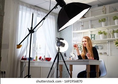 Beauty blogger woman filming daily make-up routine tutorial on camera. Influencer blonde girl live streaming cosmetics product review in home studio with professional lighting equipment. Vlogger job. - Powered by Shutterstock